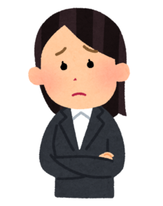 腕をくんで悩んでいるスーツを着た女性会社員